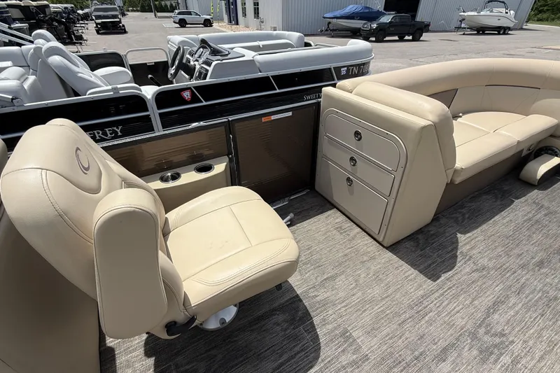 Slide: The Image of 2022 Crest Classic LX 220 pontoon boat interior with beige seating and storage compartments. - 15