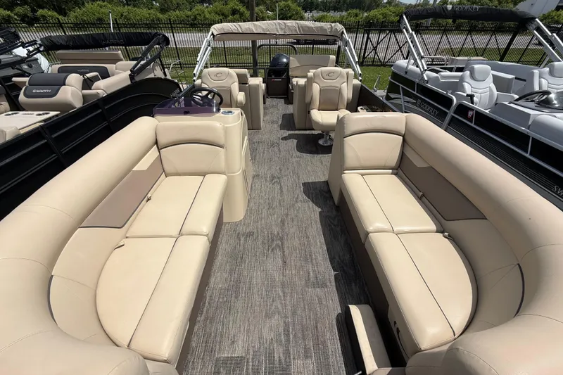 Slide: The Image of 2022 Crest Classic LX 220 pontoon boat with beige seating and spacious interior layout. - 16