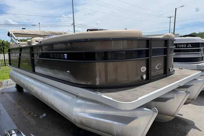 Slide: The Image of 2022 Crest Classic LX 220 pontoon boat with sleek design, docked outdoors. - 2