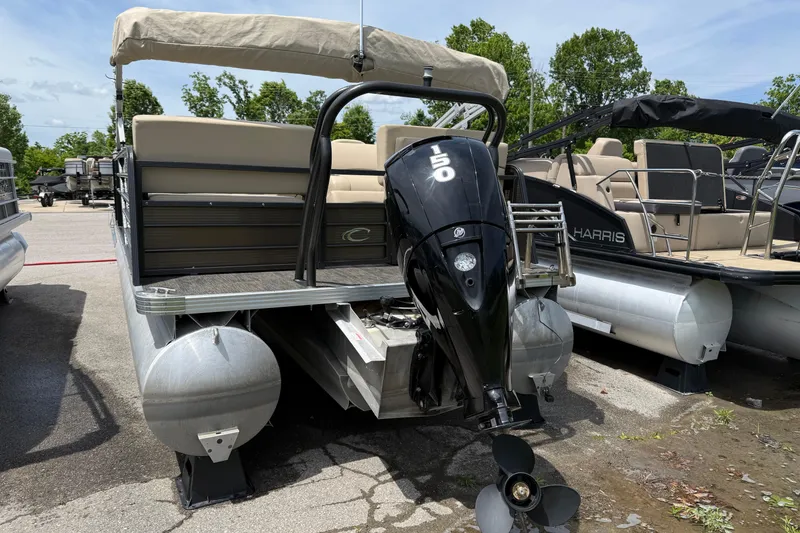 Slide: The Image of 2022 Crest Classic LX 220 pontoon boat with powerful outboard motor, parked outdoors. - 5