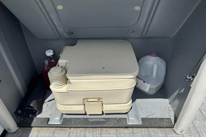Slide: The Image of Portable toilet in a 2022 Starcraft SLS 3 boat compartment with cleaning supplies. - 13