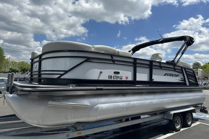 Slide: The Image of 2022 Starcraft SLS 3 pontoon boat on trailer under cloudy sky. - 6