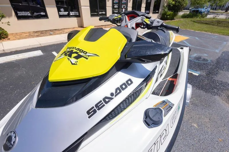 The Image of 2016 Sea Doo RXT 300 jet ski with yellow accents, parked outdoors. - 1