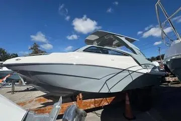 Slide: The Image of 2025 NX Boats NX280 XTREME in marina, sleek design under clear blue sky. - 4