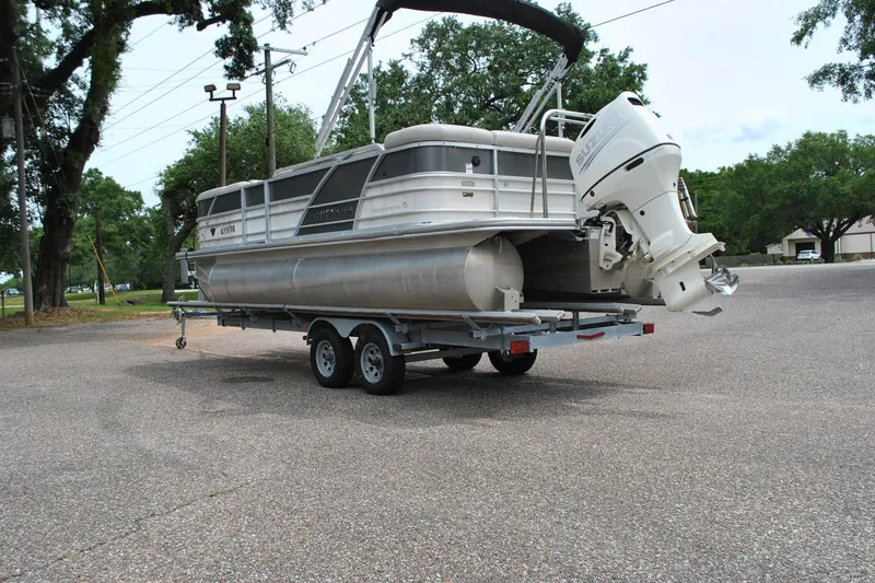 Slide: The Image of 2018 Trifecta 2.75 pontoon boat on trailer with outboard motor in parking lot. - 12