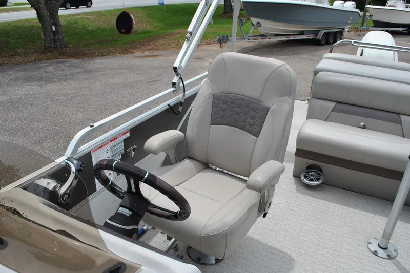 Slide: The Image of Captain's chair on a 2018 Trifecta 2.75 pontoon boat, featuring a sleek steering wheel. - 19