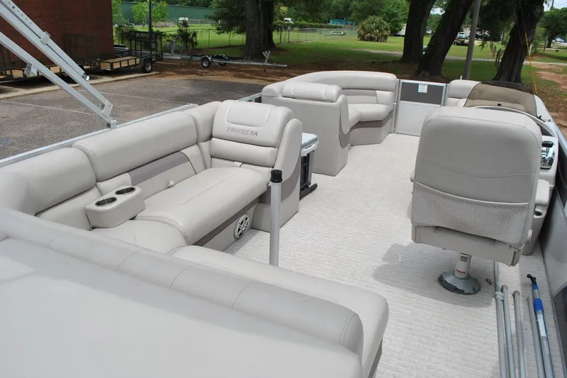 Slide: The Image of 2018 Trifecta 2.75 pontoon boat interior with beige seating and cup holders. - 24