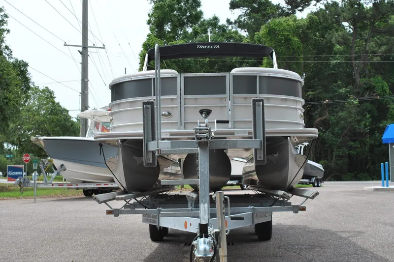 Slide: The Image of 2018 Trifecta 2.75 pontoon boat on trailer, parked outdoors. - 4