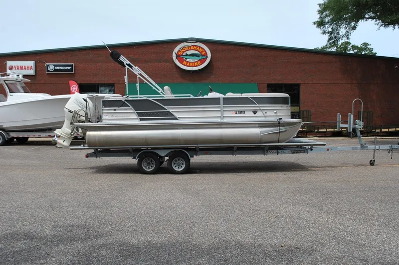 Slide: The Image of 2018 Trifecta 2.75 pontoon boat on trailer outside dealership. - 6