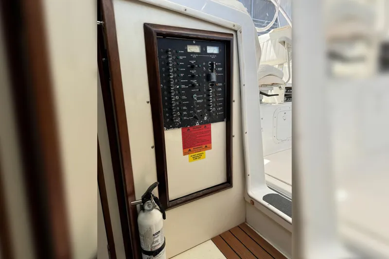 Slide: The Image of Electrical panel on 2006 Luhrs 28 Open boat with fire extinguisher nearby. - 17