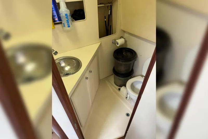 Slide: The Image of 2006 Luhrs 28 Open boat bathroom with sink, toilet, and cleaning supplies. - 18