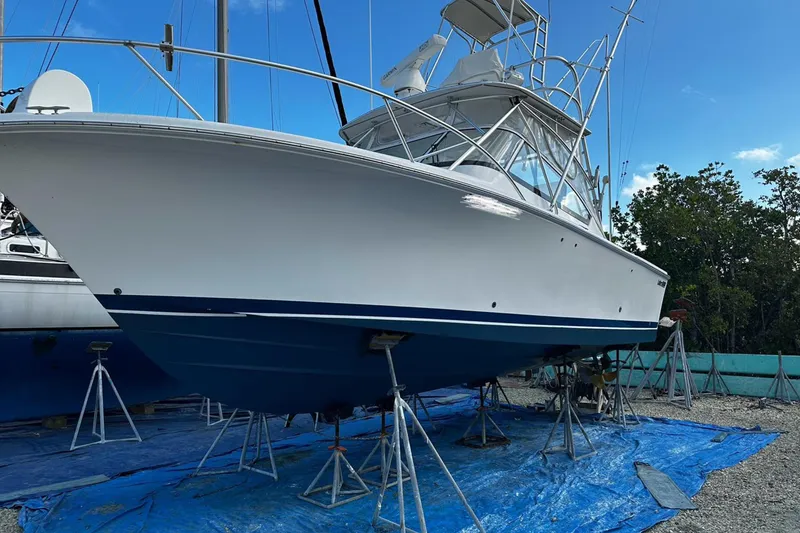 Slide: The Image of 2006 Luhrs 28 Open boat on stands, blue hull, clear sky background. - 2