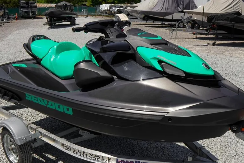 The Image of 2026 Sea-Doo GTI SE 130 jet ski on trailer, vibrant teal and black design. - 1