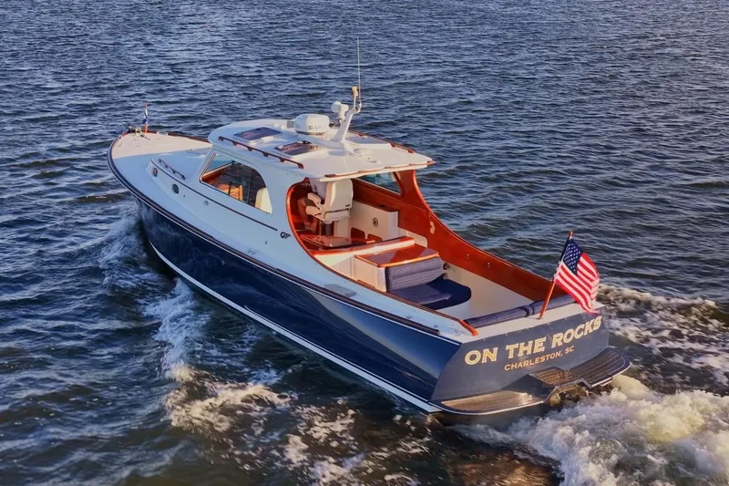 The Image of 2004 Hinckley Picnic Boat 36 EP cruising on water, displaying American flag. - 0