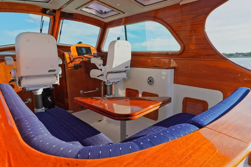 Slide: The Image of Interior of 2004 Hinckley Picnic Boat 36 EP with polished wood and blue seating. - 12