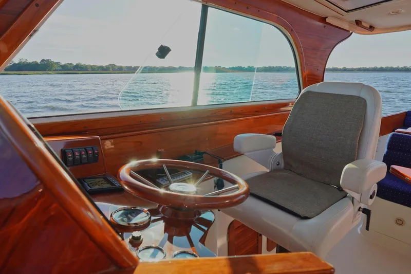 Slide: The Image of Helm of 2004 Hinckley Picnic Boat 36 EP with wooden dashboard and water view. - 17