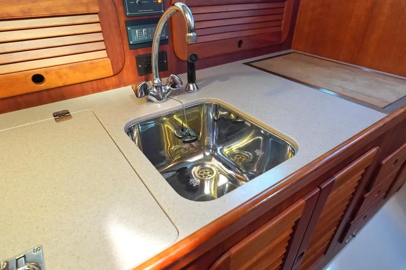 Slide: The Image of 2004 Hinckley Picnic Boat 36 EP galley with stainless steel sink and wooden cabinetry. - 20