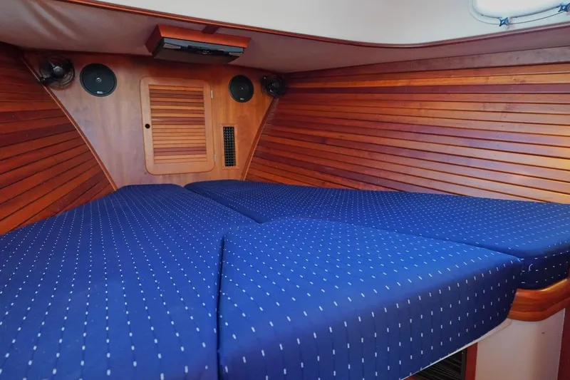 Slide: The Image of Interior cabin of 2004 Hinckley Picnic Boat 36 EP with blue cushioned bedding. - 21