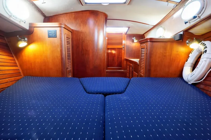 Slide: The Image of Luxurious cabin interior of 2004 Hinckley Picnic Boat 36 EP with wooden finish and blue bedding. - 22
