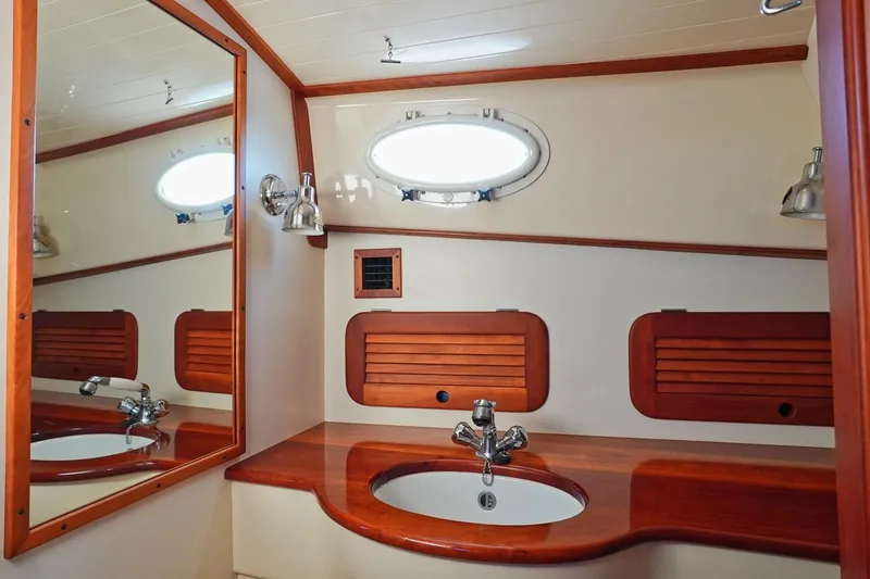 Slide: The Image of Elegant bathroom interior of 2004 Hinckley Picnic Boat 36 EP with wooden accents and oval window. - 24