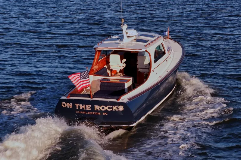Slide: The Image of 2004 Hinckley Picnic Boat 36 EP cruising on water, displaying American flag. - 28