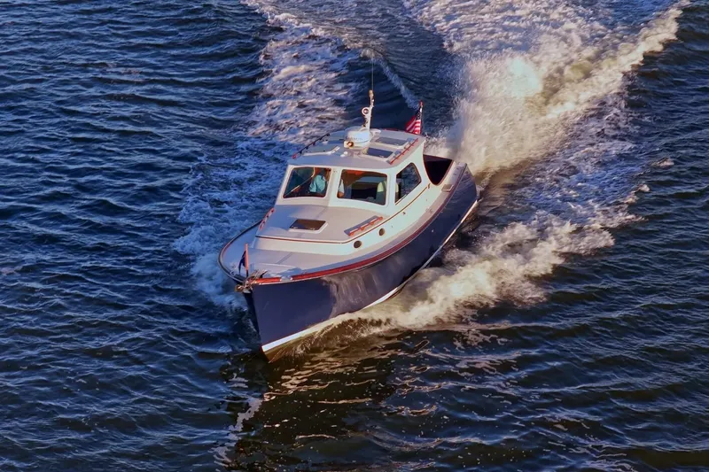 Slide: The Image of 2004 Hinckley Picnic Boat 36 EP cruising on open water, creating a dynamic wake. - 3