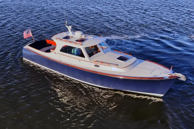 Slide: The Image of 2004 Hinckley Picnic Boat 36 EP cruising on open water, displaying elegant design and craftsmanship. - 5