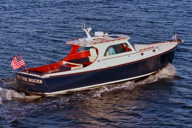 Slide: The Image of 2004 Hinckley Picnic Boat 36 EP cruising on open water with American flag. - 6