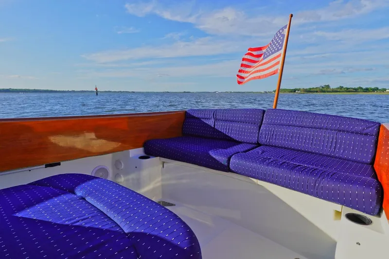 Slide: The Image of 2004 Hinckley Picnic Boat 36 EP with American flag on calm waters. - 8