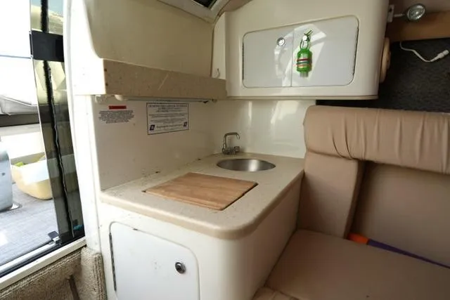 Slide: The Image of Compact kitchenette in a 2002 Cobalt 263 boat with sink and seating area. - 17