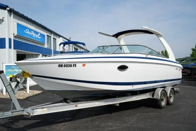 Slide: The Image of 2002 Cobalt 263 boat on trailer outside dealership, featuring sleek white design. - 2