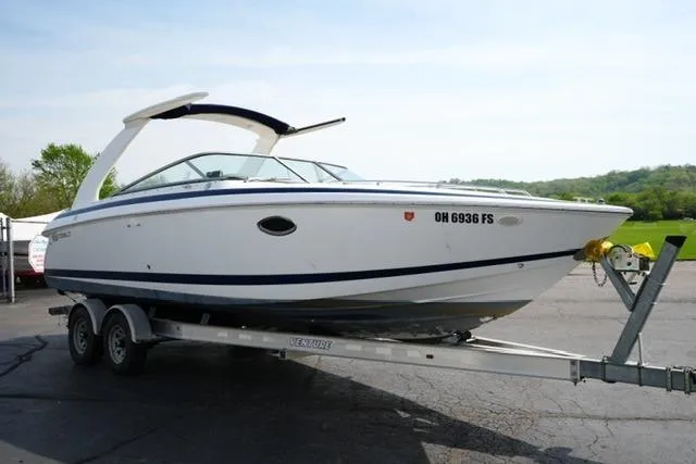 Slide: The Image of 2002 Cobalt 263 boat on trailer, parked outdoors, with scenic background. - 3