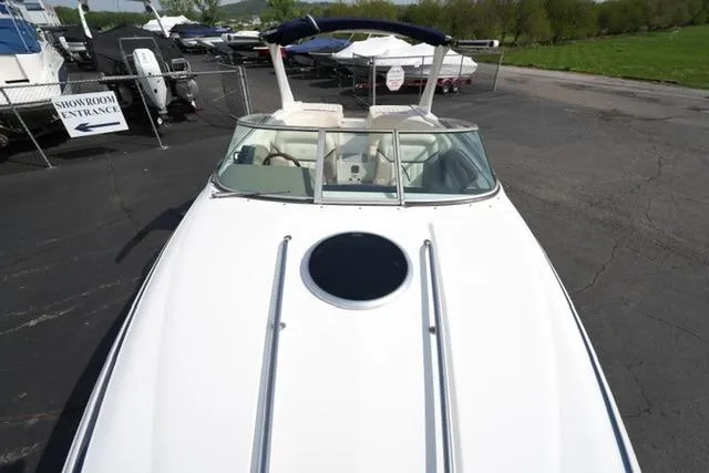Slide: The Image of 2002 Cobalt 263 boat with sleek white deck, parked near showroom entrance. - 8
