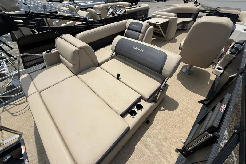 Slide: The Image of 2024 Harris Cruiser 230 pontoon boat interior with beige seating and cup holders. - 12