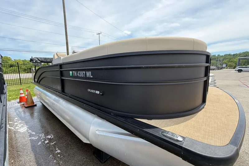 Slide: The Image of 2024 Harris Cruiser 230 pontoon boat parked outdoors on a sunny day. - 2