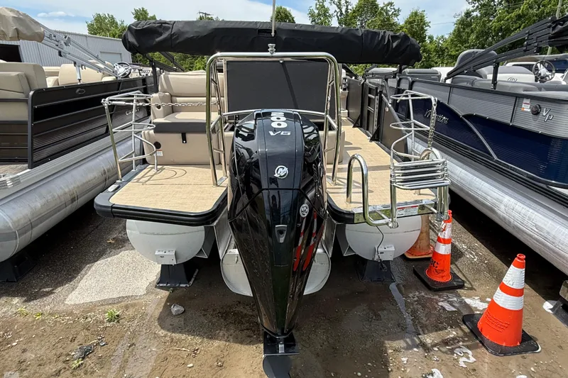 Slide: The Image of 2024 Harris Cruiser 230 pontoon boat with powerful outboard motor, docked between other boats. - 3