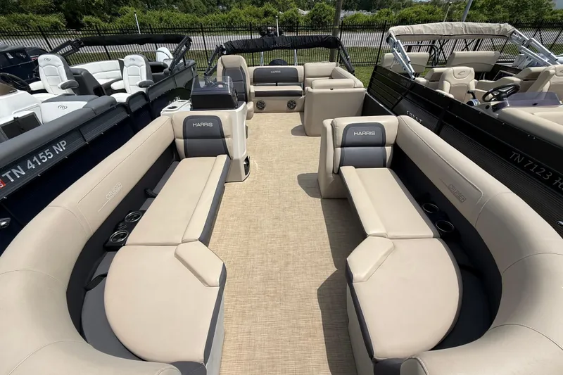 Slide: The Image of 2024 Harris Cruiser 230 pontoon boat interior with beige seating and cup holders. - 4