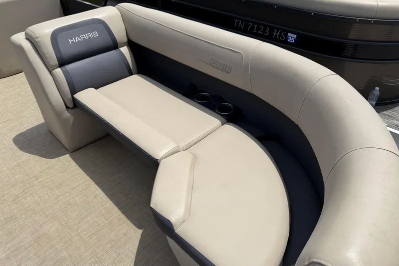 Slide: The Image of 2024 Harris Cruiser 230 boat seating with beige upholstery and cup holders. - 6