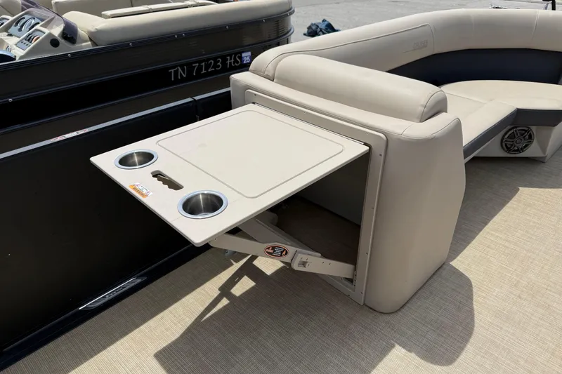 Slide: The Image of 2024 Harris Cruiser 230 boat interior with foldable table and cup holders. - 8