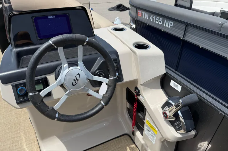 Slide: The Image of 2024 Harris Cruiser 230 boat dashboard with steering wheel and control panel. - 9