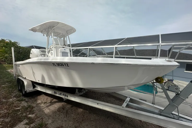 The Image of 2024 Aquasport 230 Pro Bay boat on trailer, parked outdoors. - 0