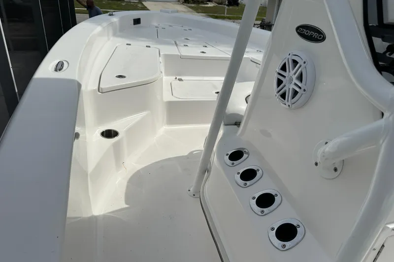 Slide: The Image of 2024 Aquasport 230 Pro Bay boat interior with rod holders and speaker. - 11