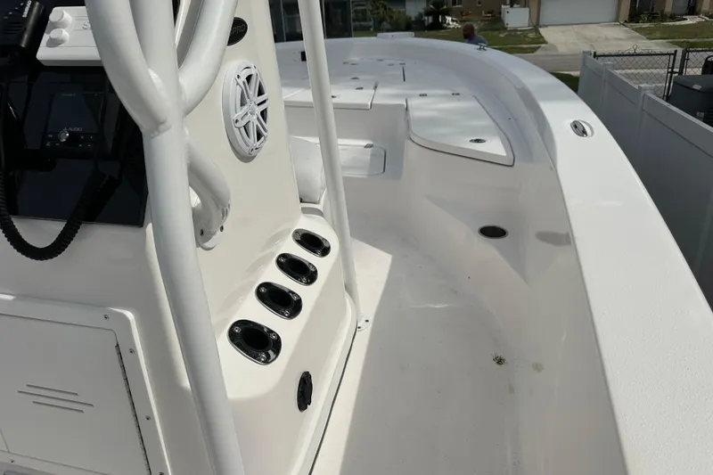 Slide: The Image of 2024 Aquasport 230 Pro Bay boat interior with rod holders and speaker. - 12