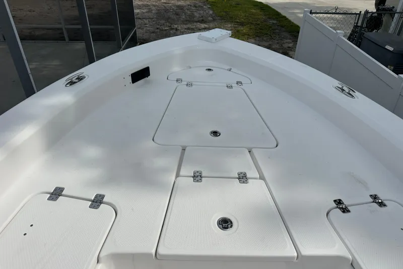 Slide: The Image of 2024 Aquasport 230 Pro Bay boat deck with storage compartments and sleek design. - 14