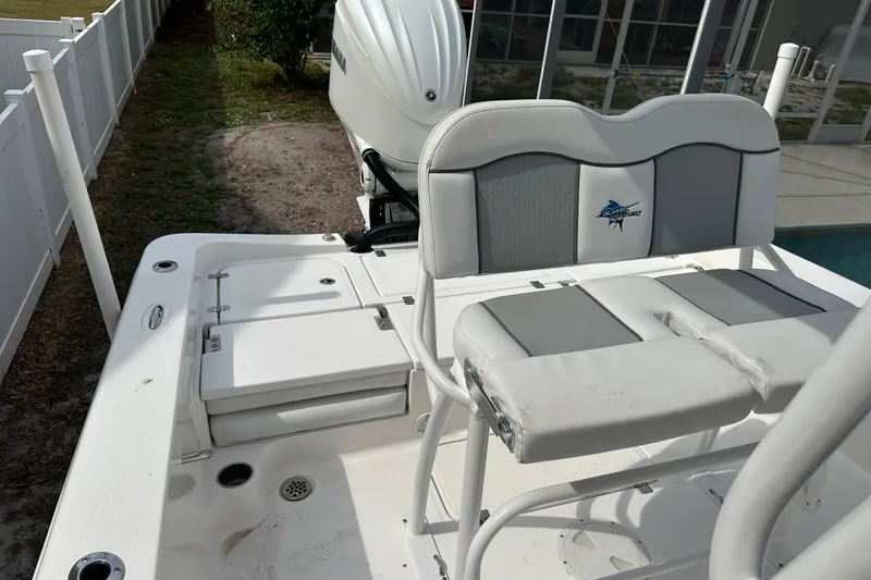 Slide: The Image of 2024 Aquasport 230 Pro Bay boat interior with seating and storage compartments. - 16