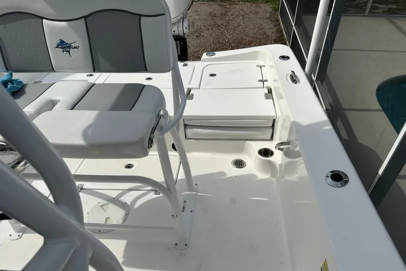 Slide: The Image of 2024 Aquasport 230 Pro Bay boat interior with seating and storage compartments. - 17