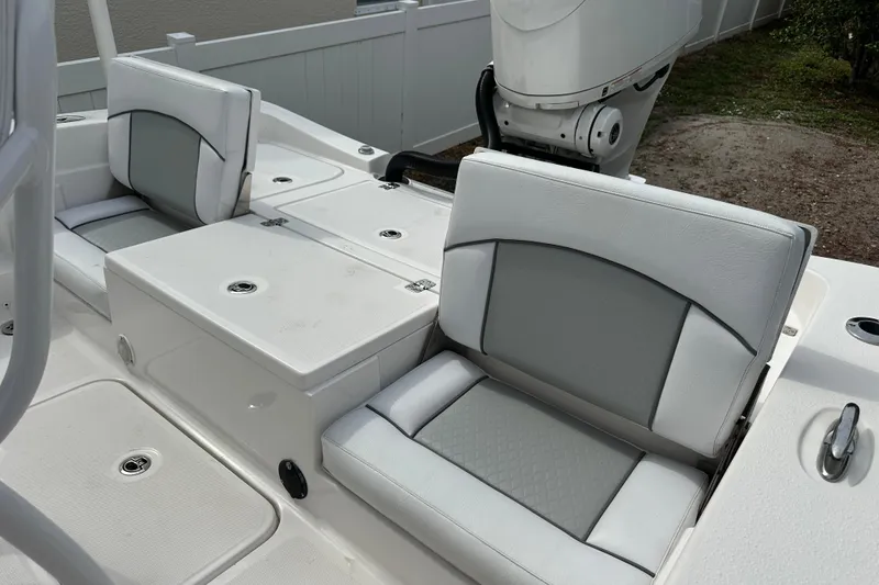 Slide: The Image of 2024 Aquasport 230 Pro Bay boat interior with cushioned seating and storage compartments. - 18