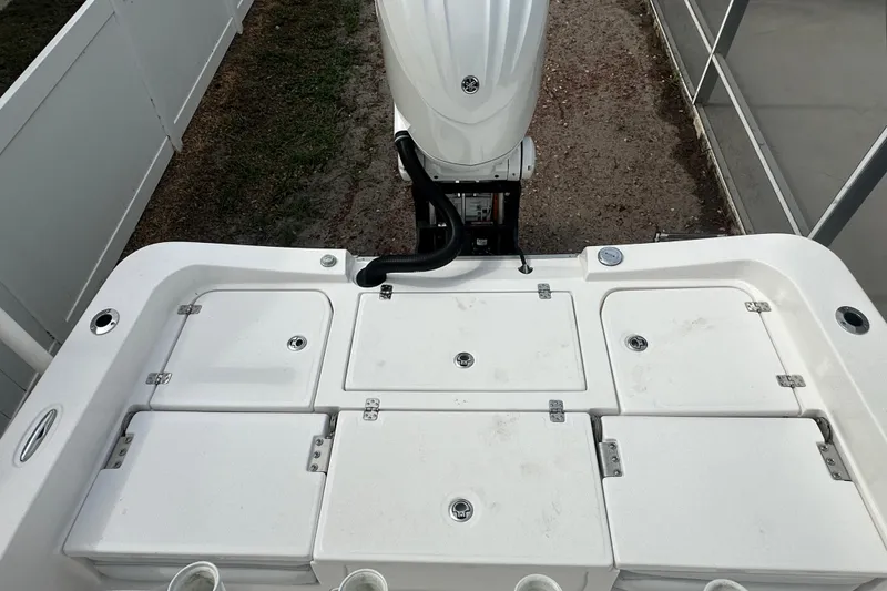 Slide: The Image of 2024 Aquasport 230 Pro Bay boat deck with storage compartments and outboard motor. - 19
