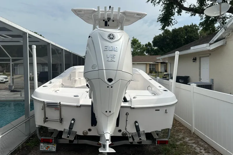 Slide: The Image of 2024 Aquasport 230 Pro Bay boat with powerful outboard motor, parked in residential driveway. - 3