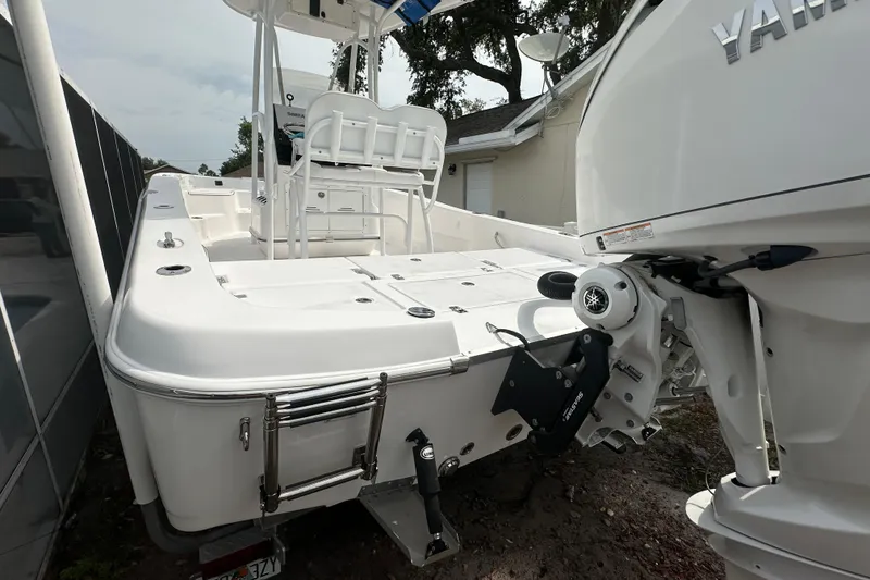 Slide: The Image of 2024 Aquasport 230 Pro Bay boat with Yamaha engine, rear view showing deck and seating. - 4